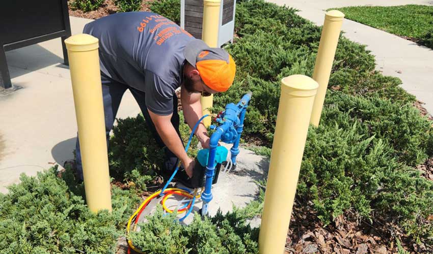 Plumber from All Hours Plumber Repairing a Backflow Prevention Device at a Tampa Apartment Complex