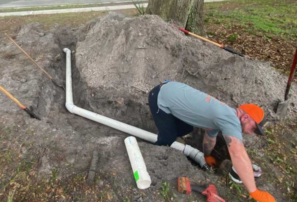 Plumber from All Hours Plumber replacing a 4" PVC sewer line in the front yard of a Tampa home