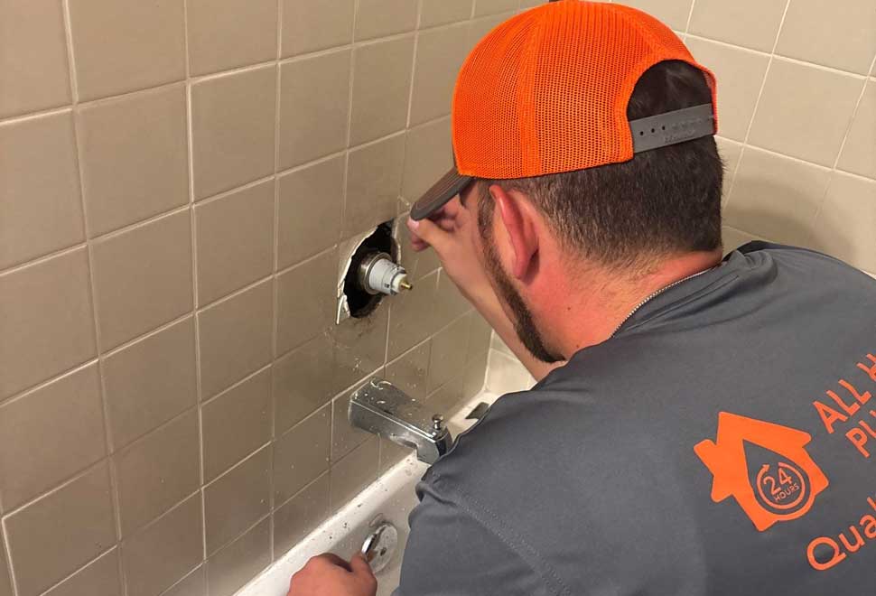 All Hours Plumber Inspecting a Shower Valve for Maintenance Needs.