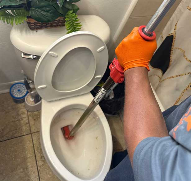Plumber From All Hours Plumber Augering a Toilet in Tampa, FL