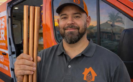 A Plumber from All Hours Plumbers in front of a service van getting ready to make a copper pipe repair in Seminole Heights, FL