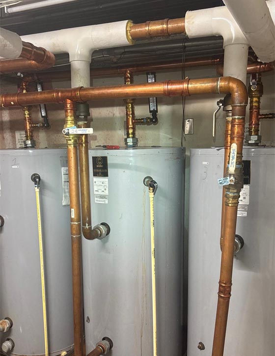 Bank of 3 commercial grade water heaters and copper supply piping in a restaurant on Westshore Blvd in Tampa, FL