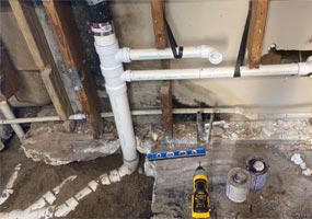 View of new PVC drain lines inside the wall and in excavated flooring for a whole house redrain for a house in Temple Terrace
