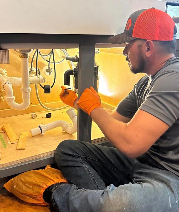 Temple Terrace Plumber fixing plumbing under a kitchen sink