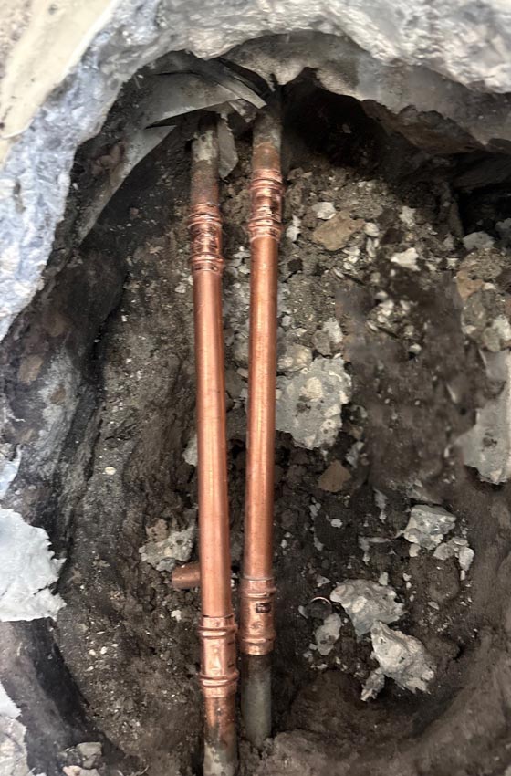View of excavated copper pipes that were leaking and repaired under a slab of a Largo, FL home.