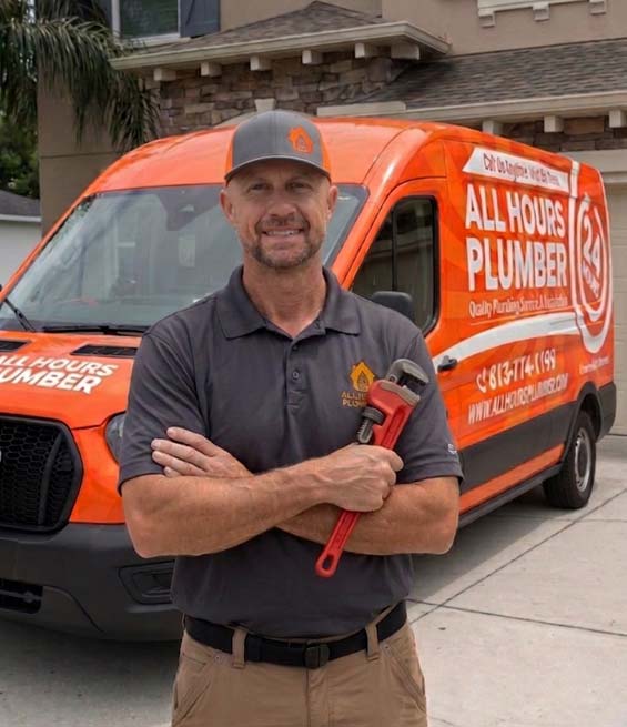 Owner of All Hours Plumber holding a plumbing wrench in front of a service van at a house in Tampa Bay