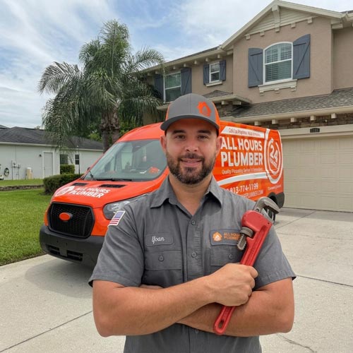 Plumber from All Hours Plumber standing in front of a plumbing van in front of a house in Tampa Bay.
